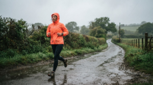 The best waterproof running jackets for UK runners in 2026 15 Runner wearing a waterproof running jacket on a rainy UK country lane