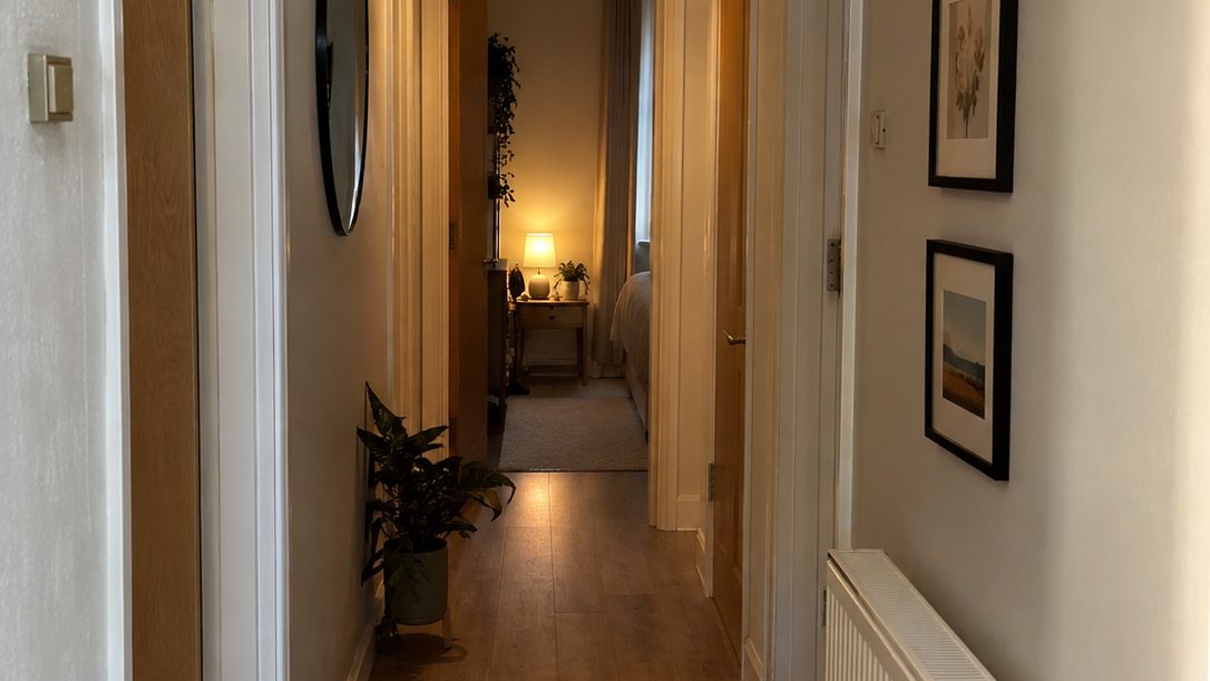 Narrow rental hallway decorated with a tight vertical row of small framed prints