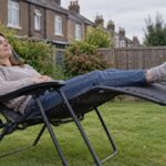 Woman reclining in a folding gravity chair on a small UK lawn